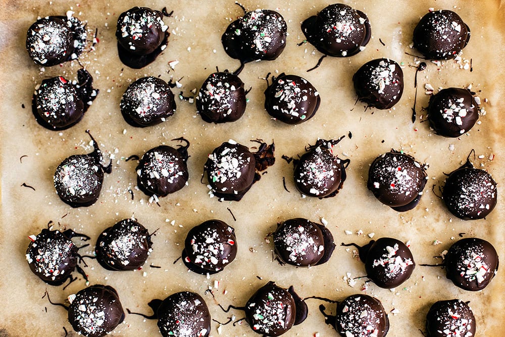 Oreo truffles dipped in chocolate setting on a tray