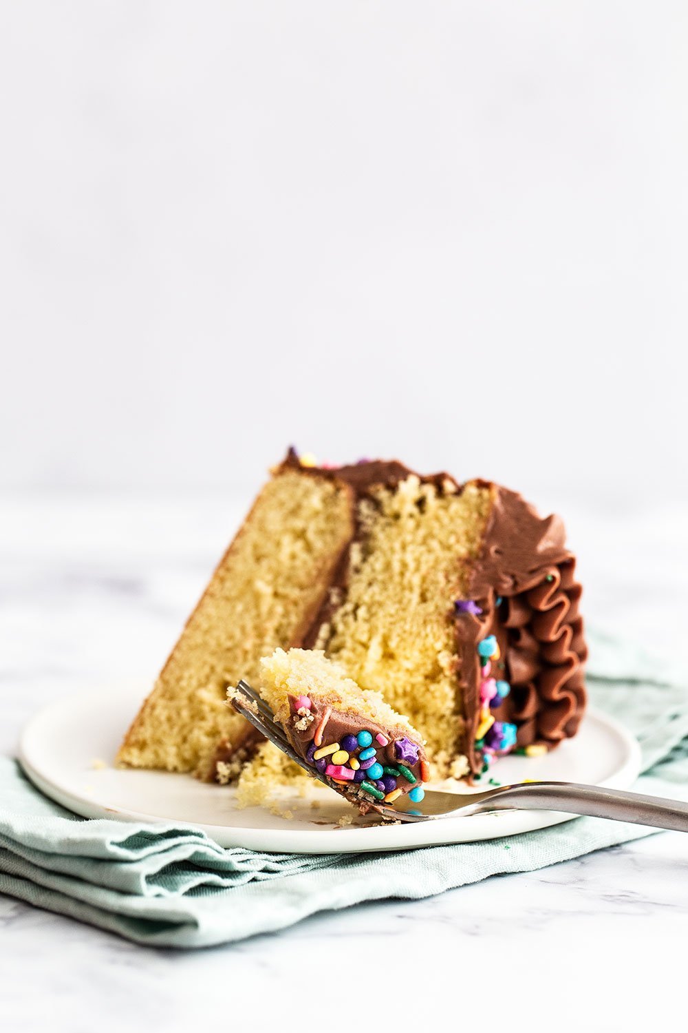 Slice of birthday cake with a piece on a fork
