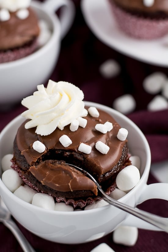 Curl up next to the fireplace with these Hot Chocolate Cupcakes dipped in chocolate frosting, sprinkled with marshmallows, and topped with whipped cream.