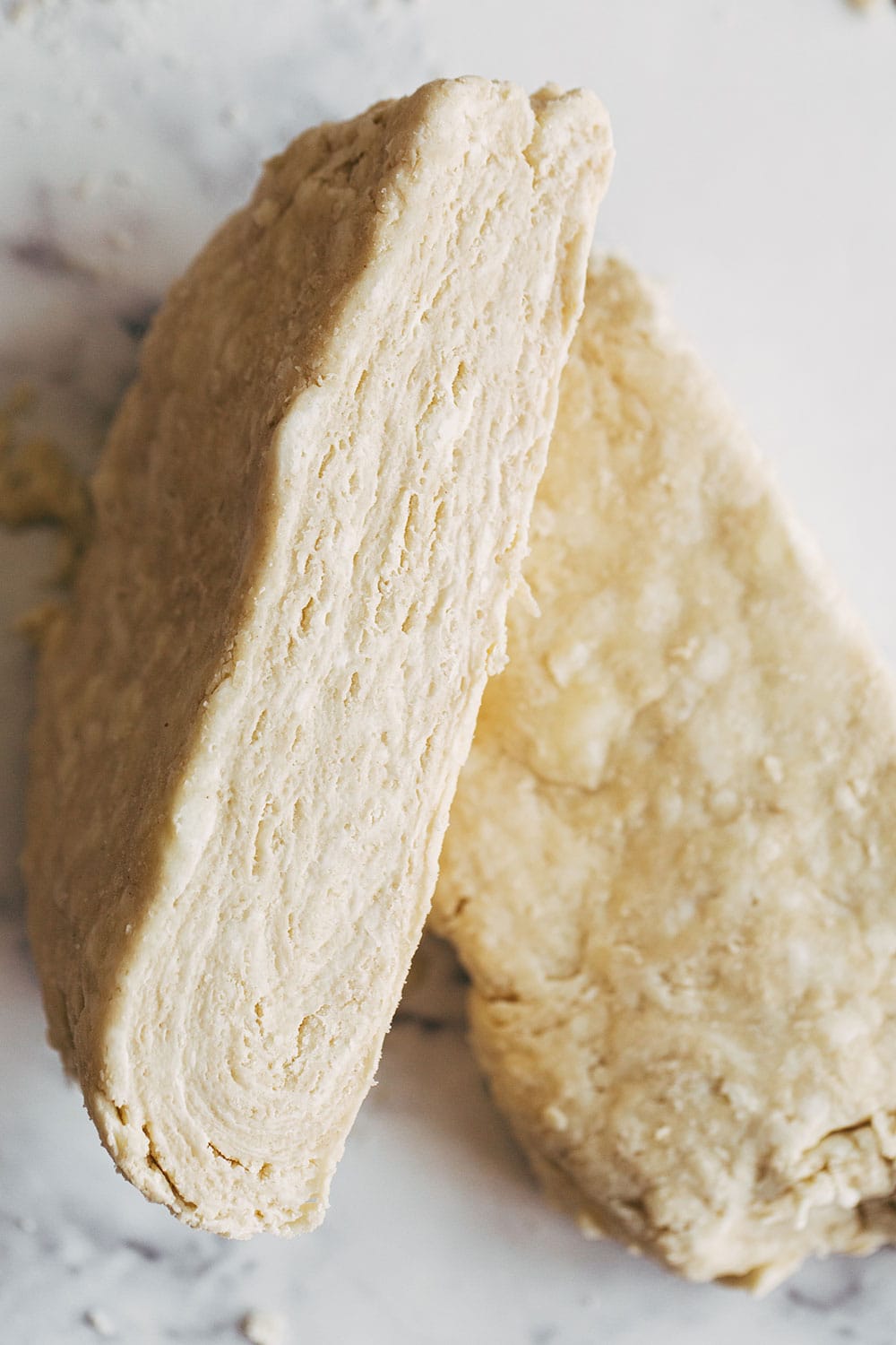 disk of pie dough cut in half to reveal layers of butter