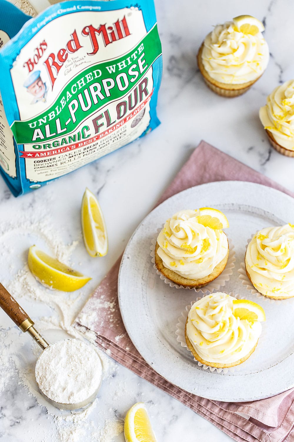 Lemon cupcakes with flour and ingredients on counter