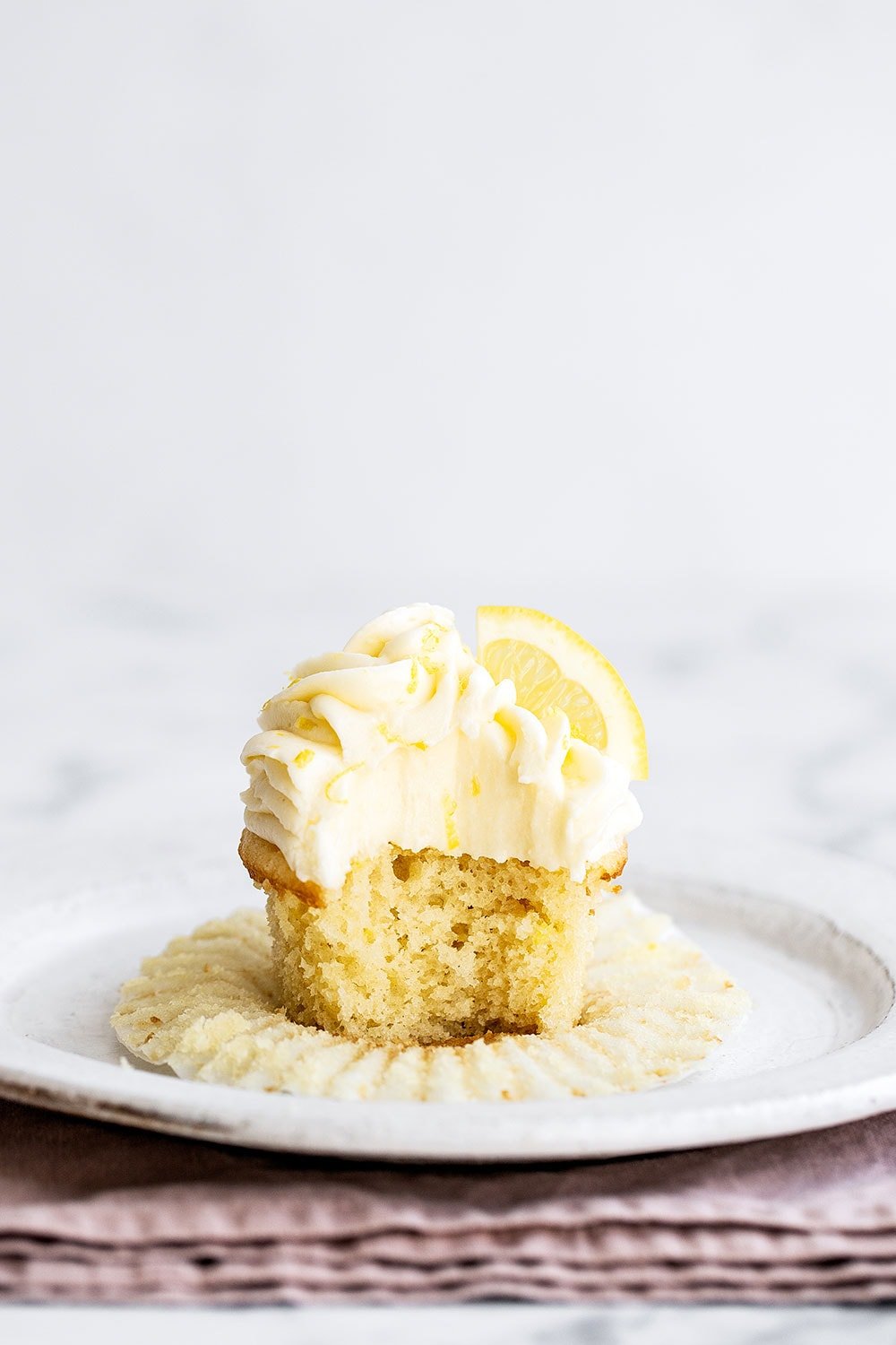 Lemon cupcake on a plate with cupcake liner removed