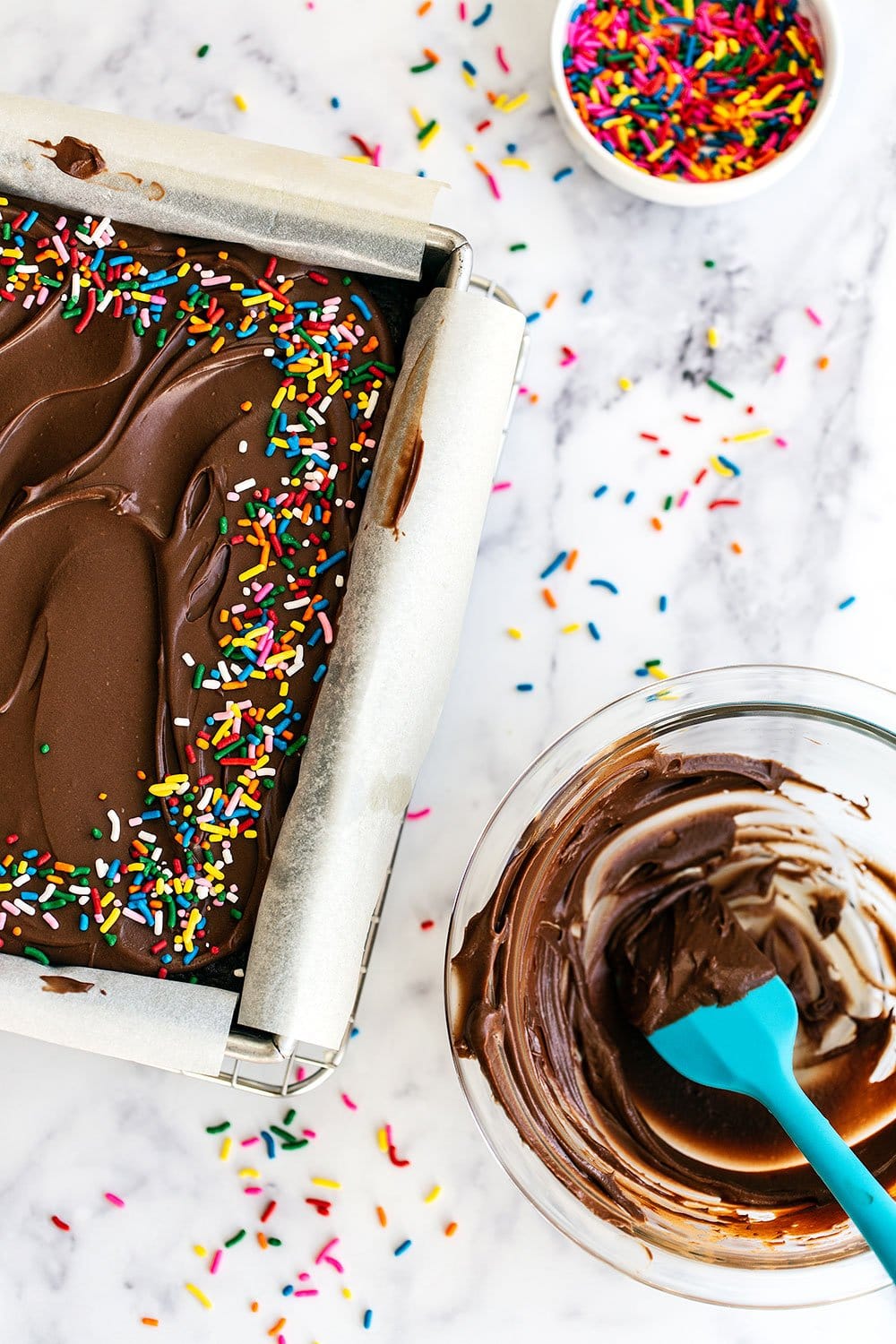 Sprinkles on cake with bowl of frosting