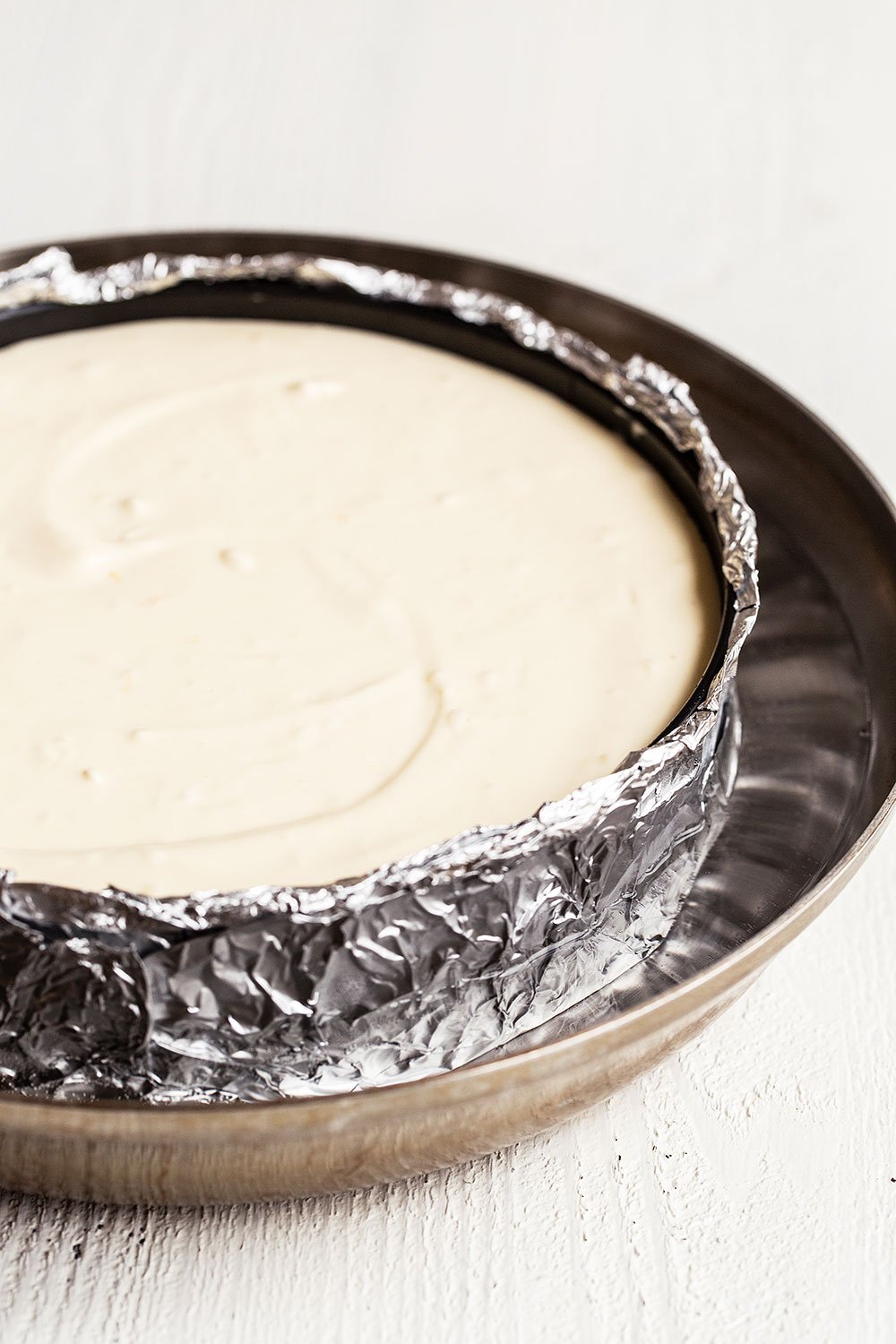 Unbaked cheesecake in pan in a water bath ready for the oven