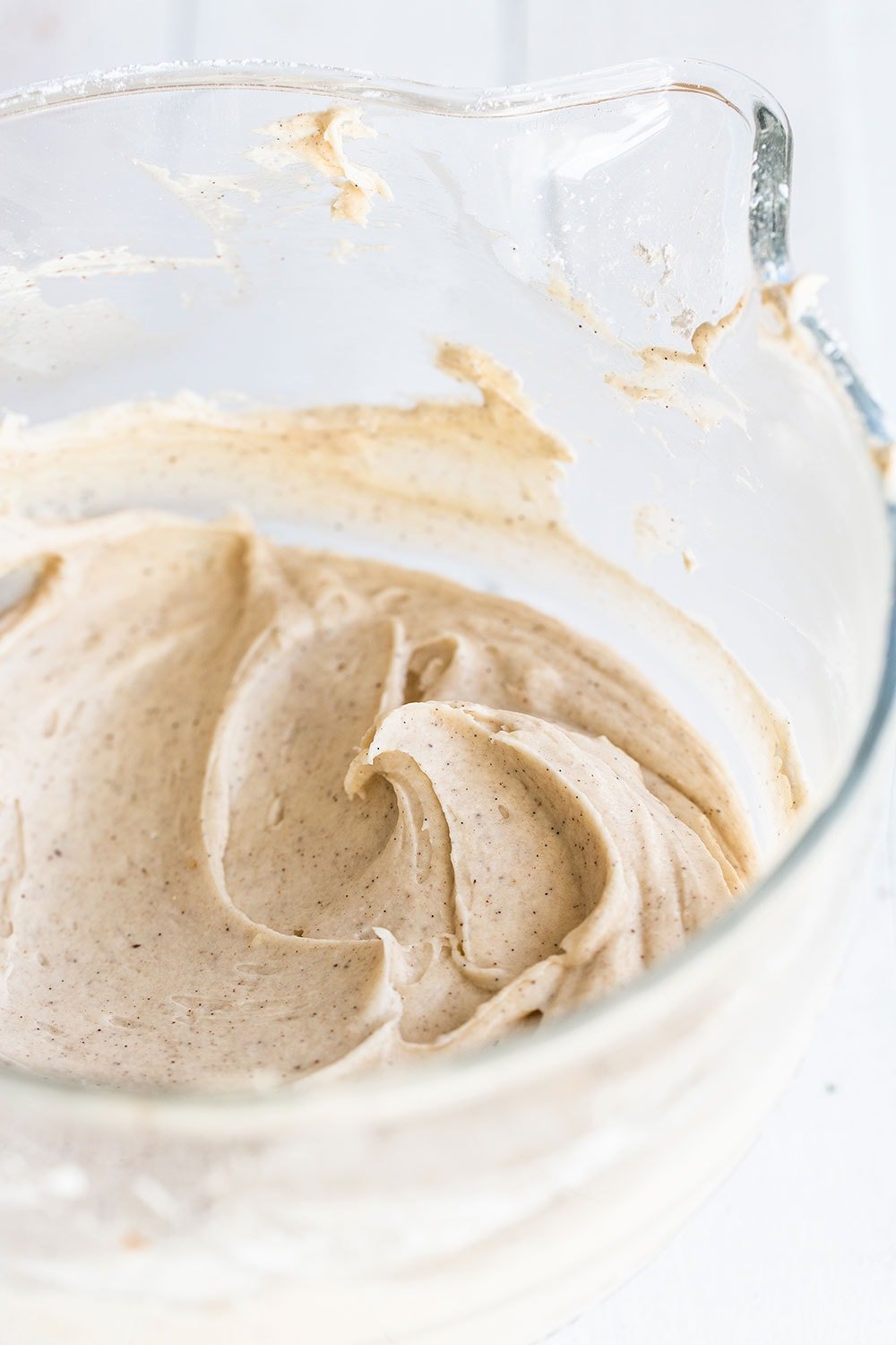 Bowl of creamy and smooth cream cheese frosting ready for carrot cake layers